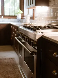 Cozinha moderna com fogão, forno embutido e armários brancos